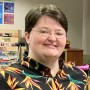Woman smiling in a birds of paradise shirt