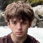 This image depicts a photograph of Paden in front of a rocky stream.