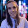 Andrew with long hair and a tie.